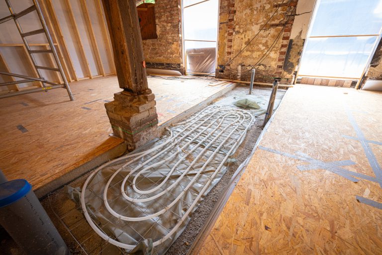 Foto van opengebroken vloer met daarin bedrading voor vloerverwarming