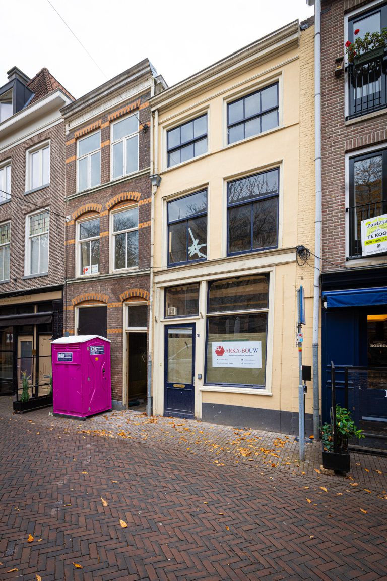 Foto van voorgevel van een oud pand in Zwolle, met roze dixi ervoor.